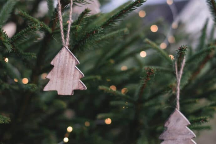 décorations en forme de sapin en bois accrochées à un sapin de noël